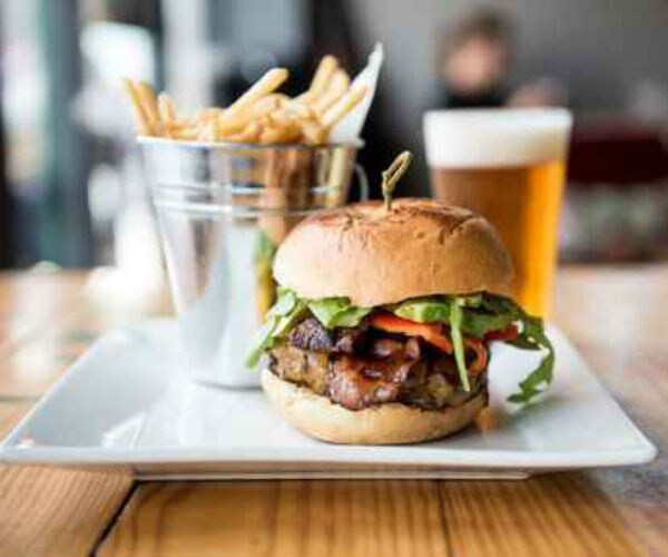 a beer, burger and fries shown