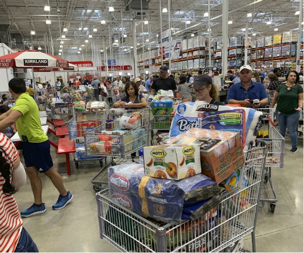 shoppers with full shopping carts wait in long lines at costco in davie florida