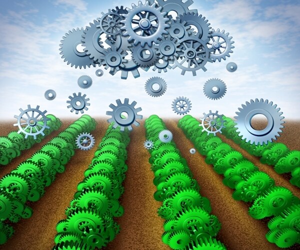 green gears and cogs as crops with a symbol of a cloud raining down data on an agricultural farm land. 