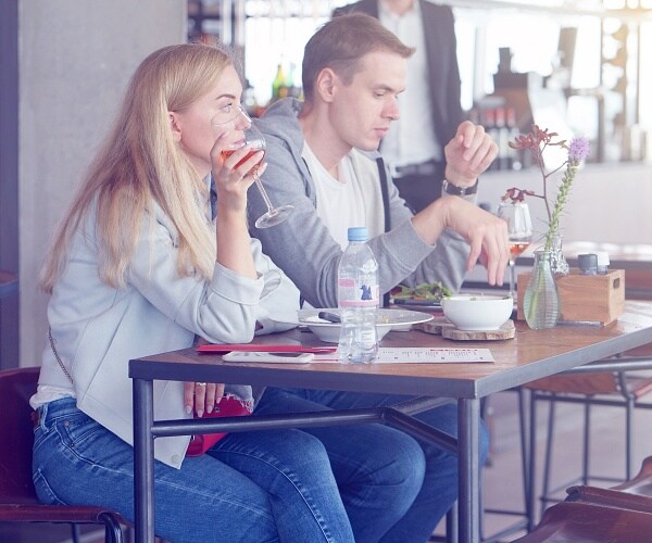 couple drinking wine and eating at cafe