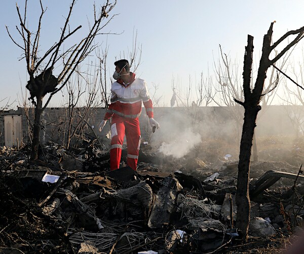 an investigator inspects the wreckage of the plane shot down by iran