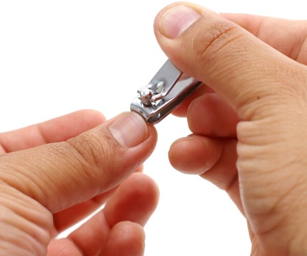 close-up of man clipping fingernails with nail clipper