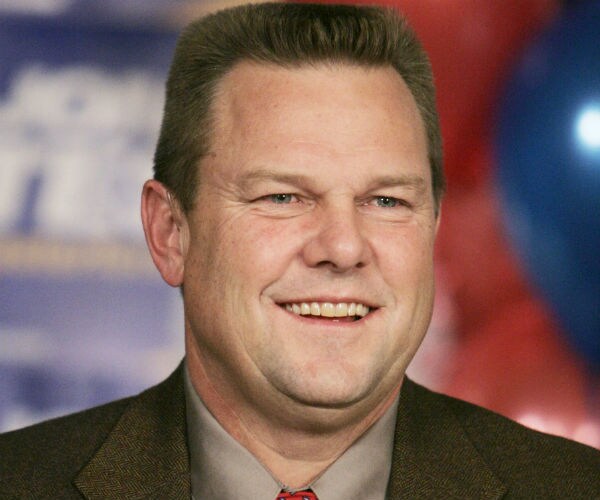 jon tester smiles wide during a news conference