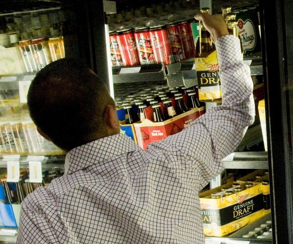 man picking up alcohol at a store