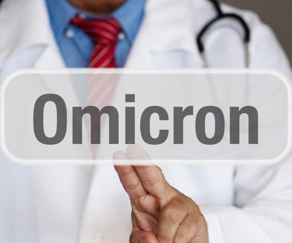 doctor in white coat touching an electronic board that says "Omicron"