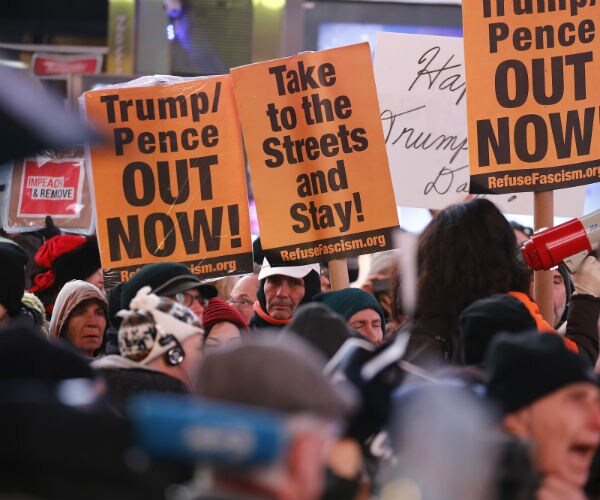 protesters with signs reading trump pence out now
