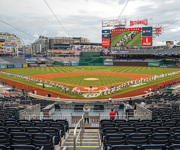 The New York Yankees and the Washington Nationals kneel while holding a black ribbon to honor Black Lives Matter