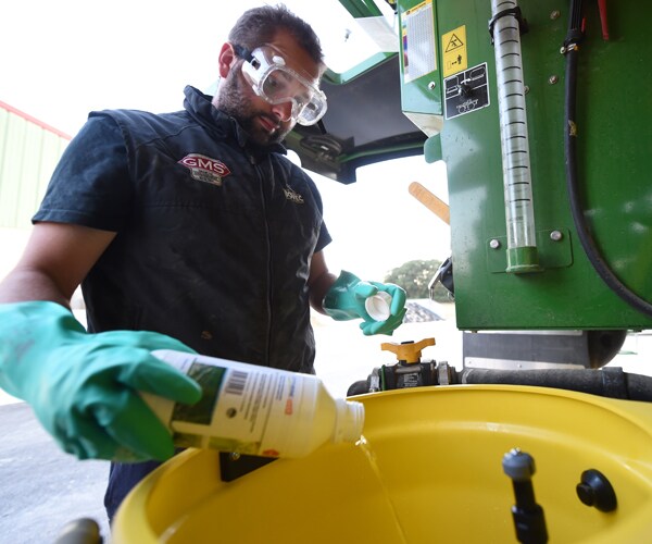 A farmer prepares a pesticide solution