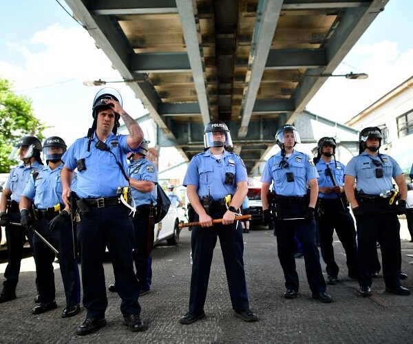 police stand in line under overpass
