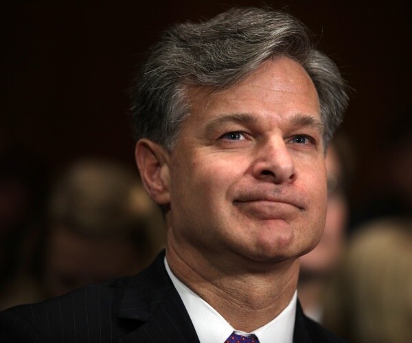 christopher wray in a white shirt and black suit is shown
