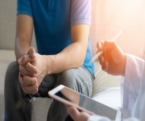 a man sitting and discussing health with his doctor