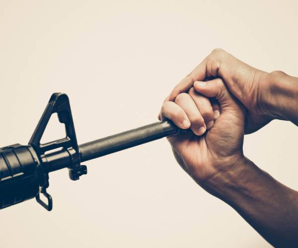 a person grabbing the barrel of a gun