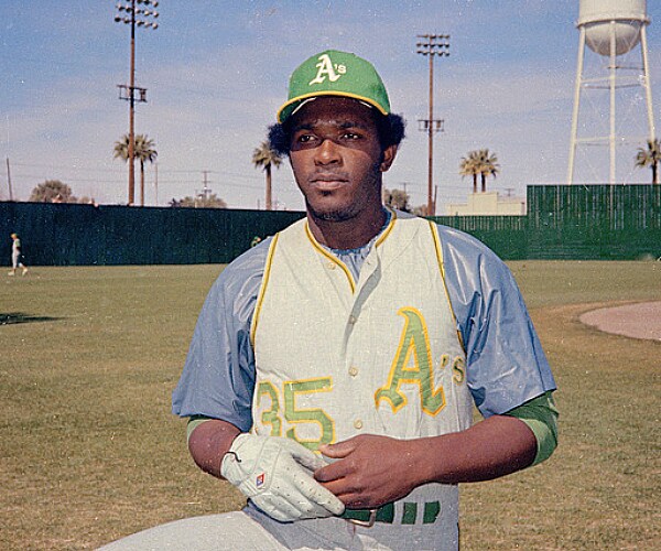 vida blue in his oakland uniform at a spring training ballpark with a palm tree in the background
