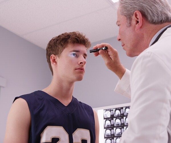 a doctor checks a patient for concussion symptoms