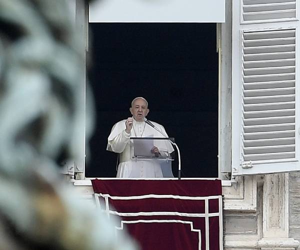 pope francis addresses a crowd from a window at the vatican