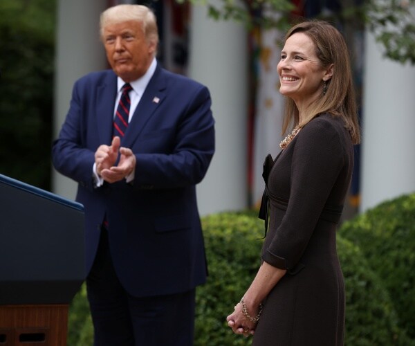 barrett smiles wearing a black dress as trump claps