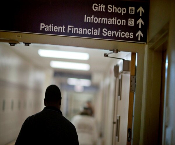 man walking down hall of hospital towards financial services office