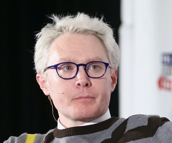 clay aiken smirks as he listens during an on-stage forum