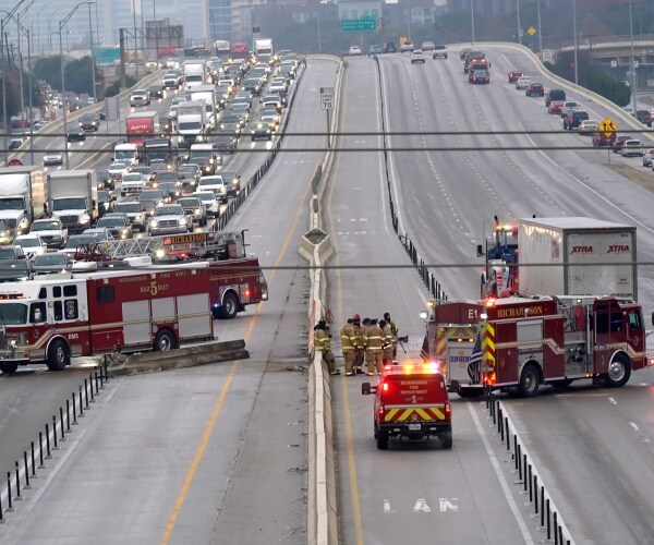 highway is shown with traffic jam on one side and firetrucks