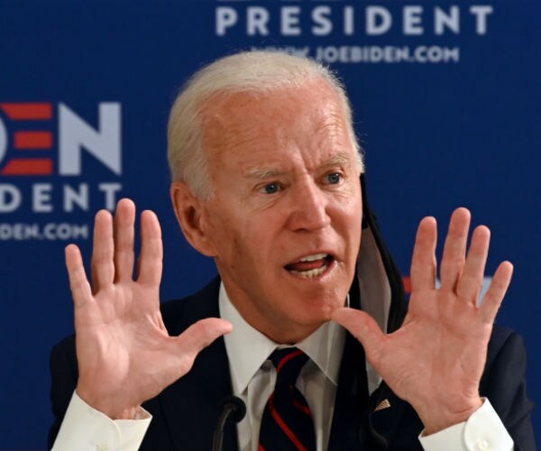 joe biden is shown holding both hands up