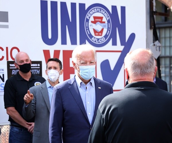 former vp job biden, wearing a mask, stands in front of a pro-union truck for the afl-cio