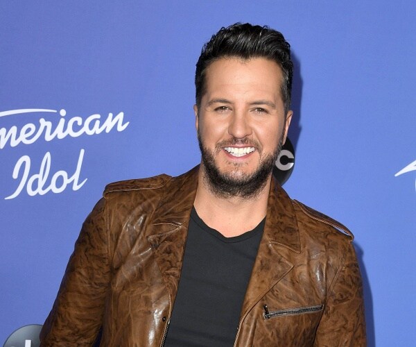 luke bryan stands on red carpet