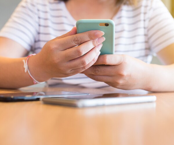 A girl using her cellphone at a coffee shop