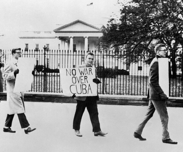 protesters carrying anti war signs in front of the white house