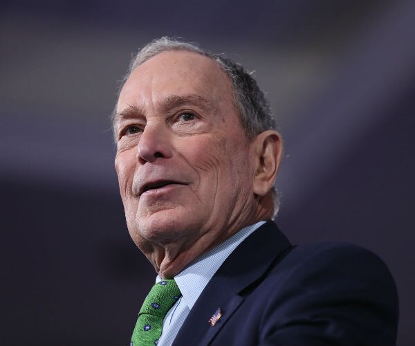 Mike Bloomberg is shown with a blue suit and dress shirt and green tie
