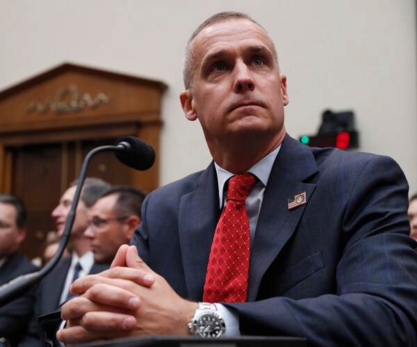 corey lewandowski sits at a desk giving testimony to the house