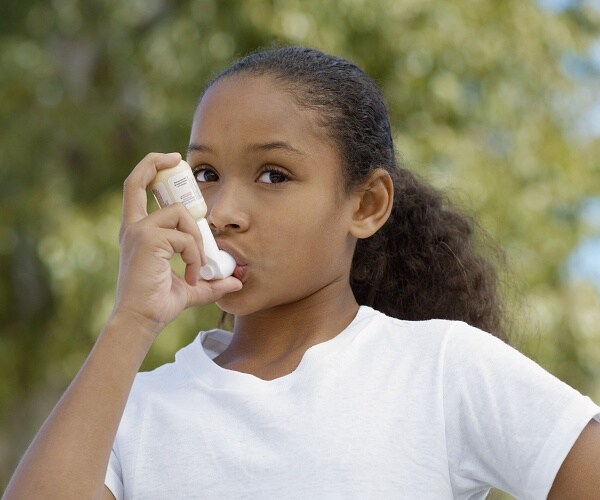 girl using asthma inhaler