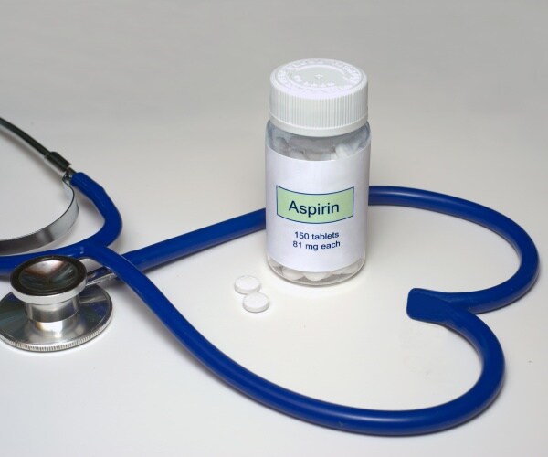 bottle of generic low-dose aspirin and stethoscope in shape of heart