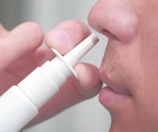 close-up of man using nasal spray