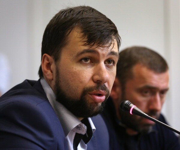 denis pushilin speaks into a microphone
