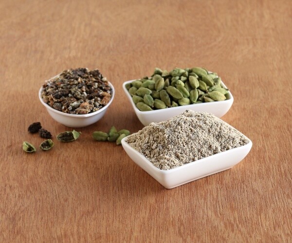 cardamom powder, seeds and pods in different bowls