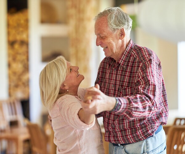 an older couple dancing together at home