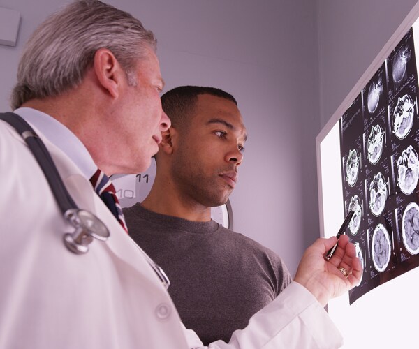 a doctor looking at a brain scan with a patient