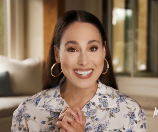 Meena harris in a white floral blouse and gold hoop earrings addresses the dnc