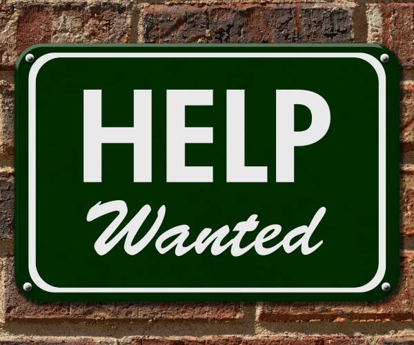 help wanted sign on a brick wall
