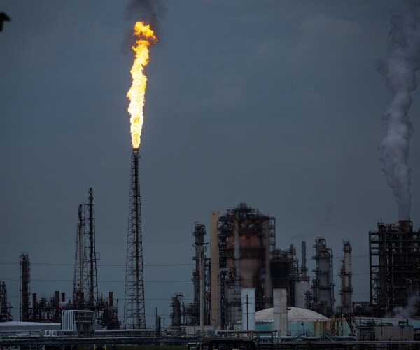 gas flare at an oil refinery on a dark cloudy day