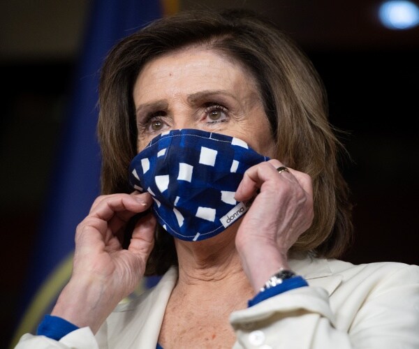 pelosi wearing a blue mask and white coat