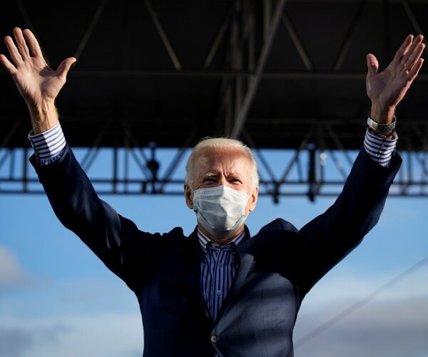 joe biden raises hands in air