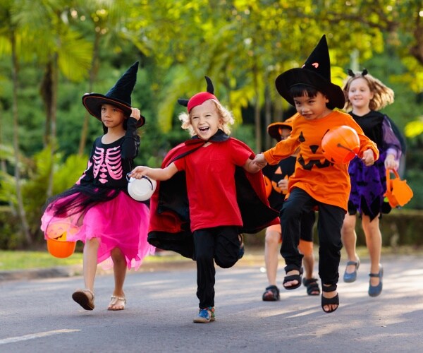 kids in costume running in street on Halloween