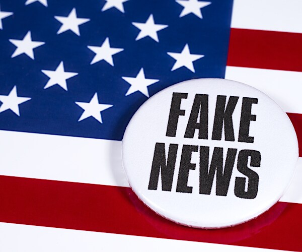an american flag with an emblem reading fake news