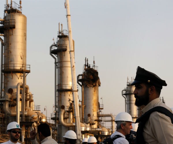 a security guarder stands alert in front of Aramco's oil processing facility