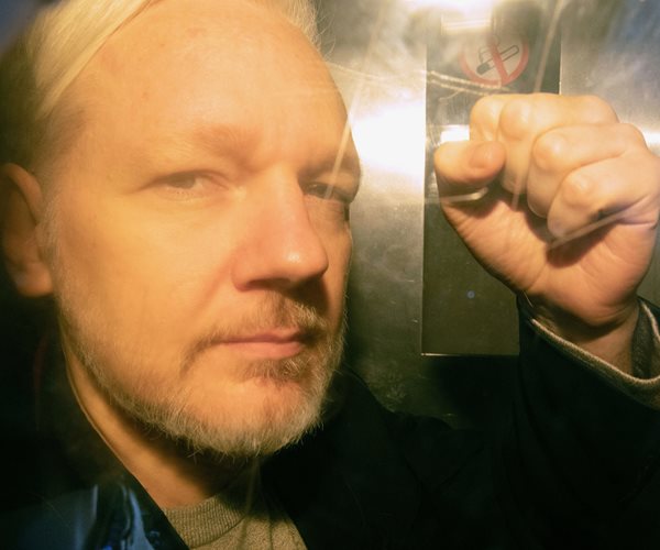 julian assange with left fist raised