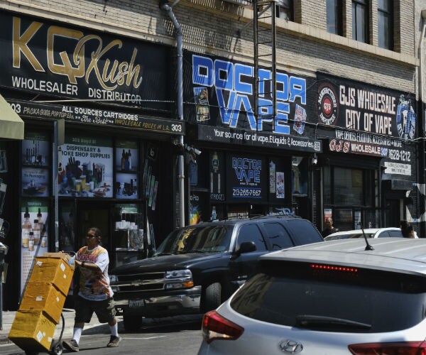 a bustling street lined with wholesale vape shops in downtown los angeles. 
