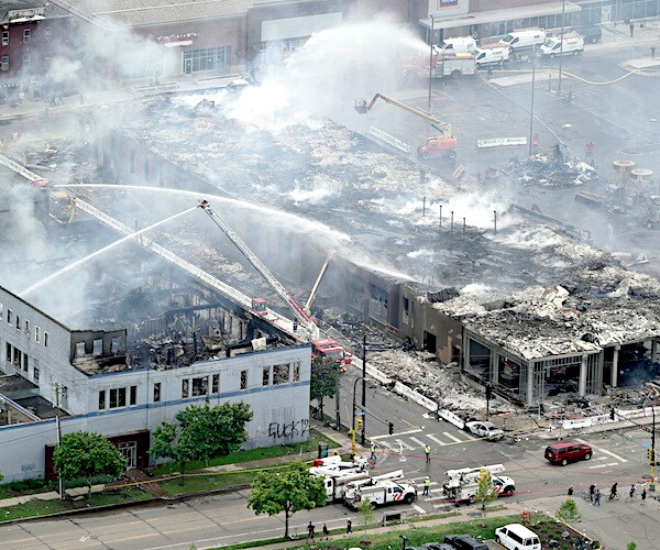 Firefighters battle a blaze set by Minneapolis rioters