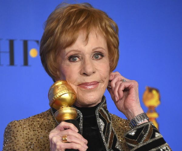 carol burnett holds her golden globe and tugs on her ear