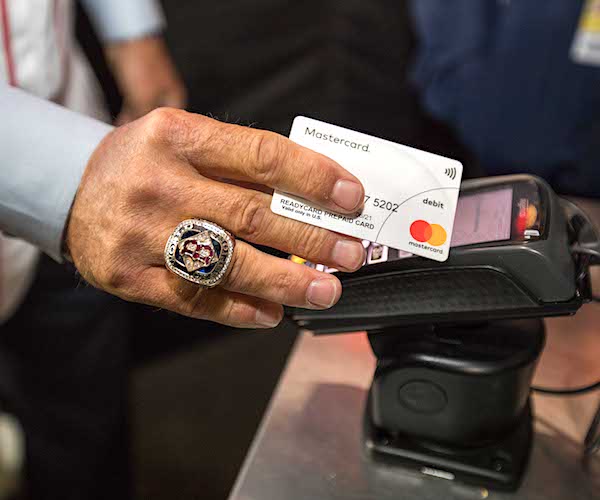 a man with a world series ring uses a mastercard tap to pay